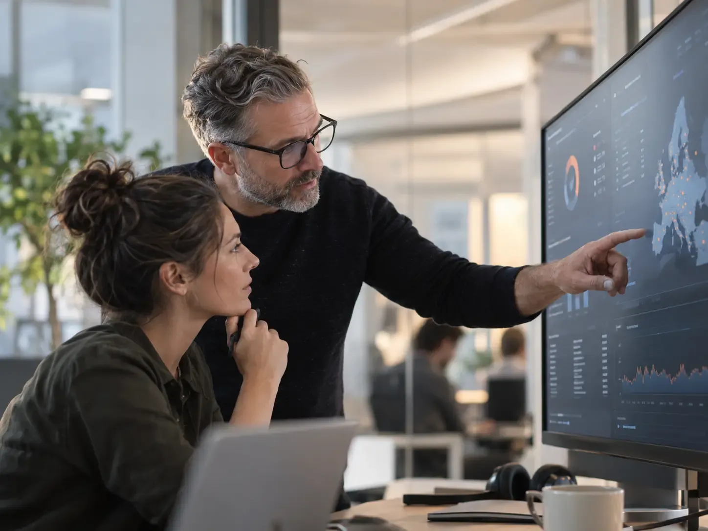 Two IT specialists reviewing a security dashboard together.